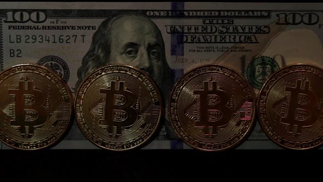 Gold coins bitcoins on the background of dollars.