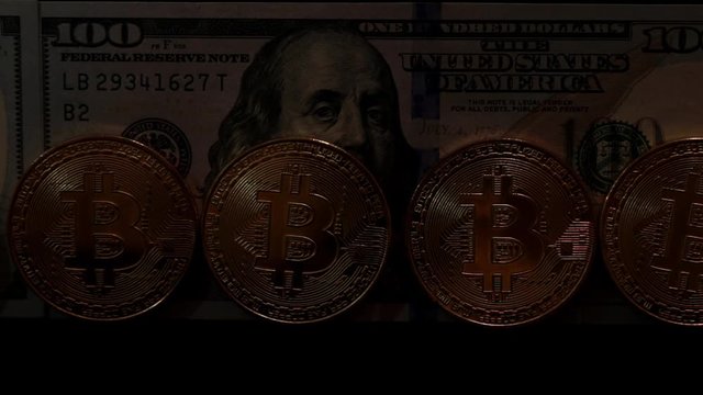 Gold coins bitcoins on the background of dollars.