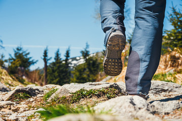 hiker walking on path in the mountains. Close up of shoes