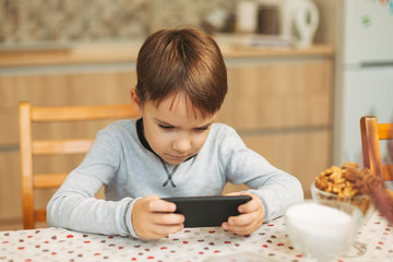 Little boy holding a phone in his hands 