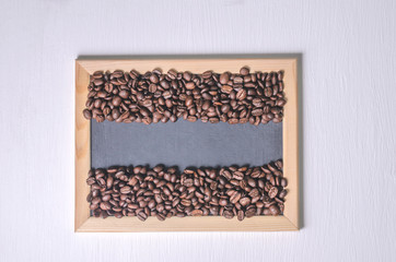 Coffee beans in a wooden frame on a white background top view, free copy space