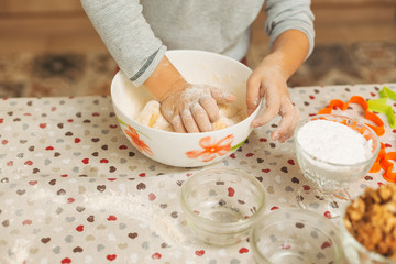 Obraz na płótnie Canvas Close-up child hands making dough for biscuits 