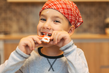 Cute boy eating Christmas cookies 