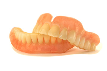 plastic full removable denture of human teeth closeup isolate on white background
