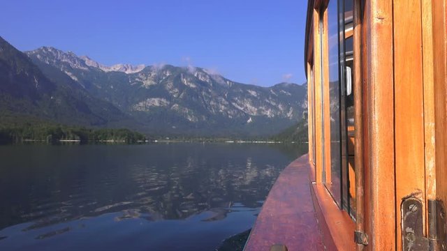 Motorboat sailing on lake Bohinj in Slovenia. Travel destinations and beauty in nature.