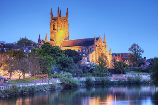 Worcester Cathedral floodlit on a spring evening and reflected in the River Severn.