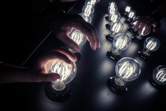 People touching light bulbs