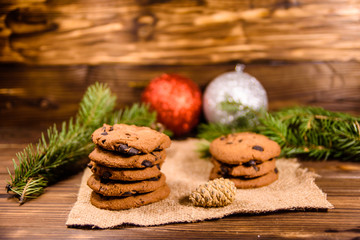 Obraz na płótnie Canvas Chocolate chip cookies and christmas decorations on a wooden table