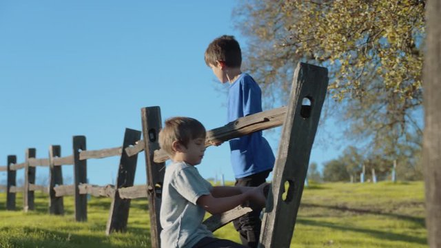4k Two boys fixing a fence working together on a farm, stock footage