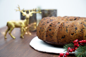 German Christmas cake Stollen on a wooden cake stand covered in powdered sugar