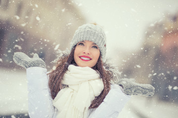 Beautiful smiling young woman in warm clothing. The concept of portrait in winter snowy weather