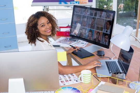 Female executive working over graphic tablet at her desk in
