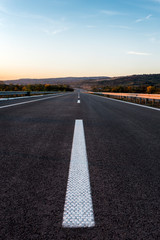 Empty Highway with markings at sunset