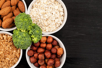 Nuts and cereals in a white ceramic dishes with broccoli