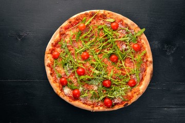 Pizza Primavera. Cherry tomatoes, arugula, cheese. On a wooden background. Top view.