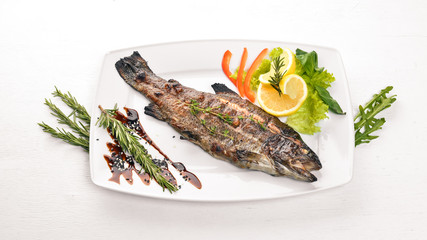 Fish Trout baked with vegetables and spices. On a wooden background. Top view. Free space for text.