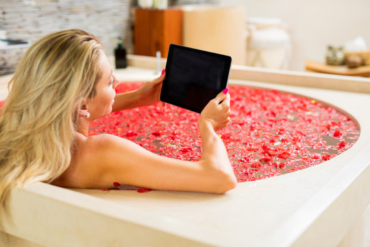 Woman using digital tablet in bathtub