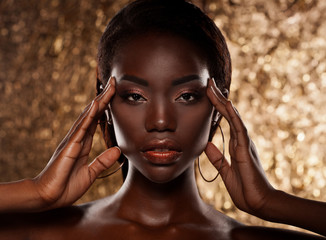 Naklejka premium portret zmysłowej młodej kobiety afrykańskie na złotym tle