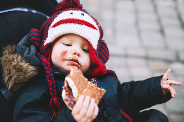 Obraz premium Child eating Trdlo or Trdelnik - Traditional National Czech Sweet Pastry Dough.