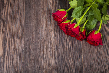 Red roses on a wooden background.