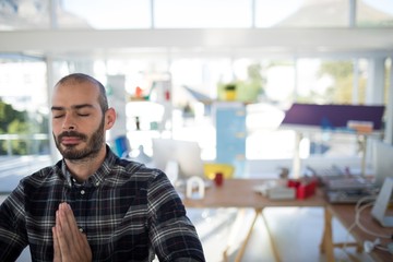 Male executive doing yoga in office