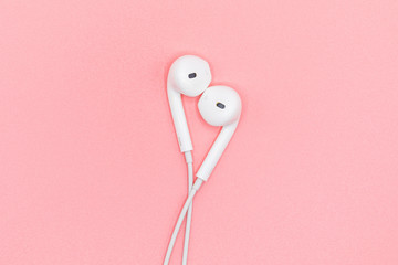 Top view of White Earphones on Pink Pastel plastic texture background. Pastel color concept, Minimal concept. Copy space. Music is my life concept