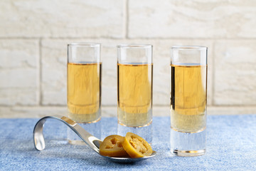 three portions of the Golden tequila with slices of marinated hot green jalapeno pepper