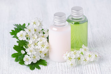 Obraz na płótnie Canvas natural cosmetic bottles with fresh flowers, white and green