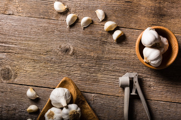 Obraz na płótnie Canvas Garlic, Garlic cloves and Garlic bulb in vintage handmade wooden bowl on old table. Top view.