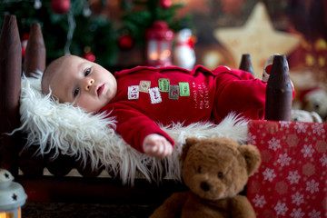 Portrait of newborn baby in Santa clothes in little baby bed