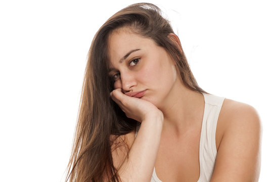 Borred young woman on a white background