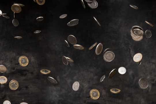Rain of polish coins on dark background - a computer screen showing the price of a computer
