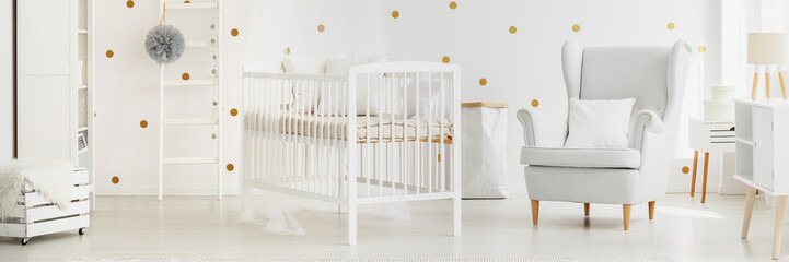 White baby nursery with armchair
