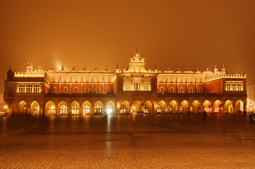 Obraz premium Market hall at main Cracow square at misty night with golden sky