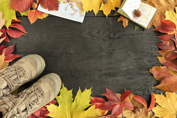 Autumn leaves, tracking boots and maps on a black background of an old tree