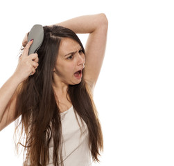 Fototapeta premium young beautiful woman has a problem with the combing her long hair