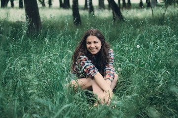 Naklejka premium Beautiful girl is stylish and fashionably dressed in the park