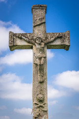 Stone cross on abandoned Catholic cemetery near Chervonohorod Castle ruins in Ukraine