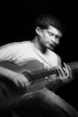 Handsome young musician playing on guitar. Double exposure concept.