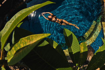 beautiful girl swims in the pool, view from the top