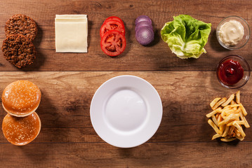 Ingredients to build the perfect hamburger - top view of wooden table