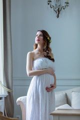 Fototapeta premium Young pregnant woman in white dress