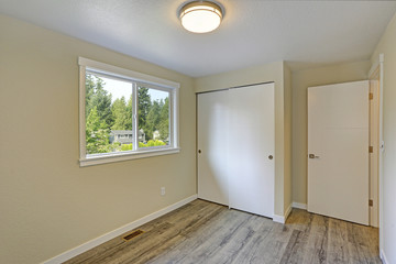 Bright beige empty room with grey hardwood floor