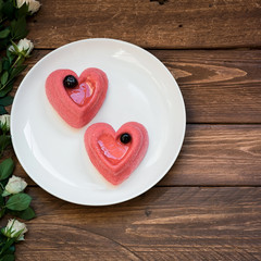 Two cakes in the form of hearts on a wooden table
