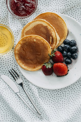 top view of delicious pancakes with berries on dotted napkin