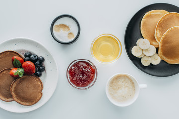 top view of breakfast for two with pancakes and coffee on white table