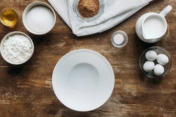 top view of ingredients for pastry and empty bowl on wooden table