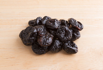 A portion of dried bing cherries on a wood cutting board.