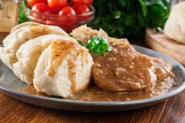 Pork loin in gravy with bread dumplings and sauerkraut