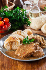 Pork loin in gravy with bread dumplings and sauerkraut